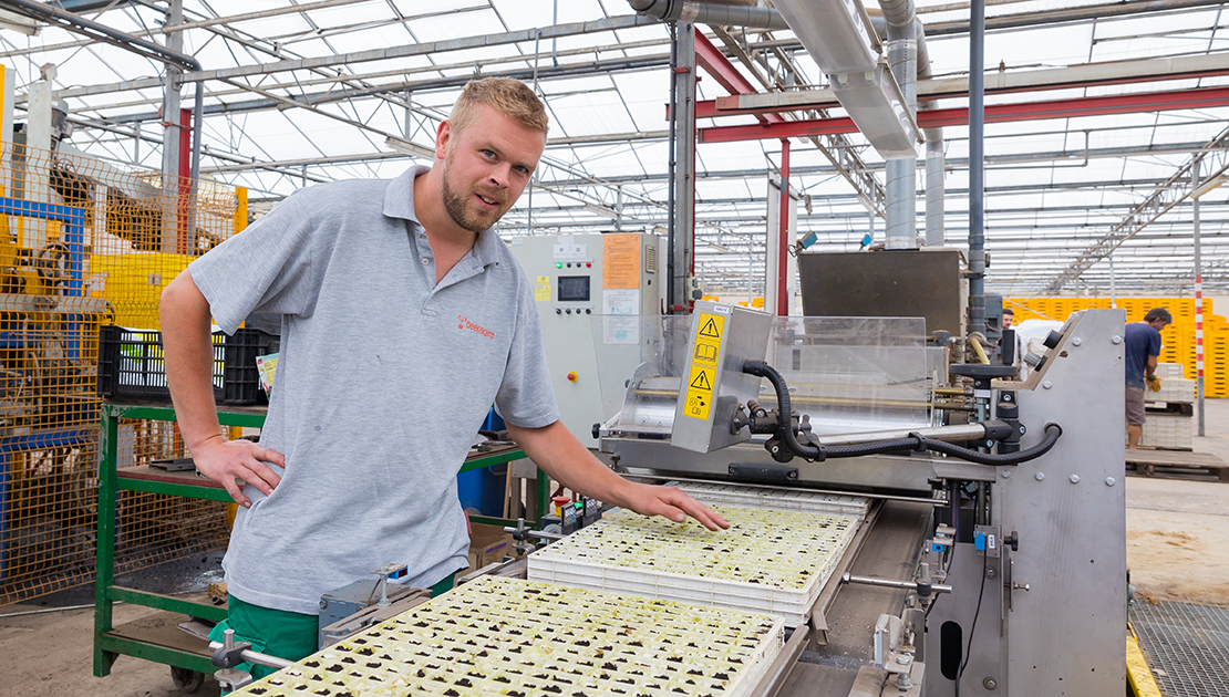 Medewerker Gijs van der Knaap bij een zaaimachine.